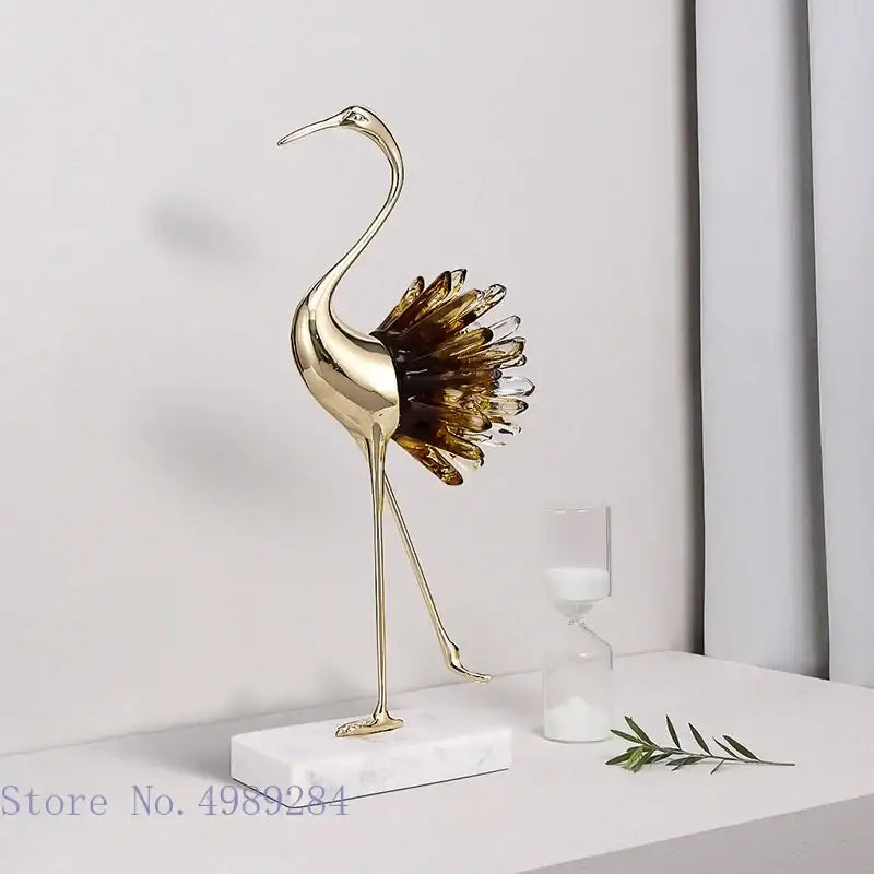 Golden bird agate crane statue with translucent amber glass feathers on white marble base for home decor