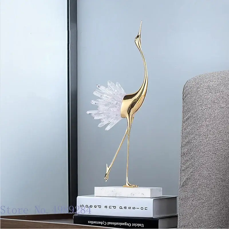 Golden bird agate marble crane statue with crystal feather detail on white marble base for home decor