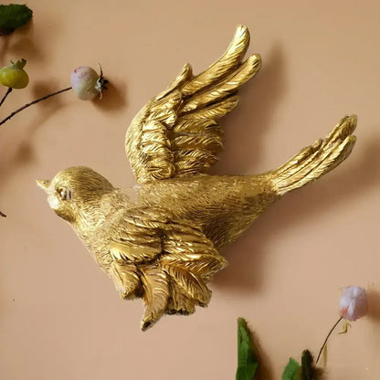 Golden bird and butterfly resin wall decor featuring detailed feathered wings with a sleek metallic finish for living room