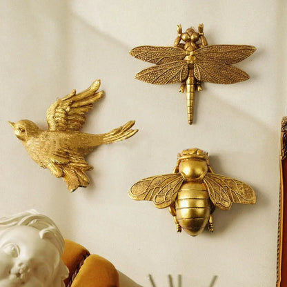Golden bird and butterfly resin wall decor featuring detailed golden metallic dragonfly bird and bee for living room