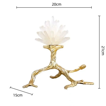 A white quartz crystal cluster resting on a golden bird metal branch sculpture with intricate natural detailing