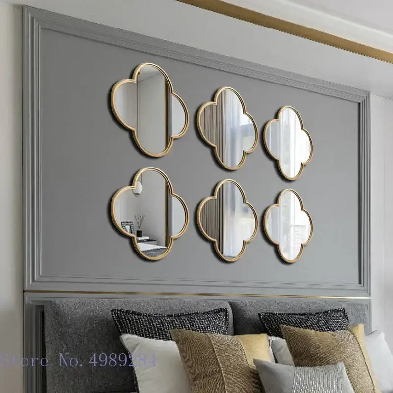Six gold-framed cloud-shaped geometric plum flower mirrors with golden border arranged on gray living room wall decor