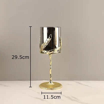 A gold-toned decorbites golden branches candle holder with silver cylinder and leaf embellishments for dining room decor