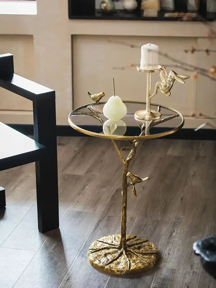Golden brass bird tree side table with glass top and intricate branch design featuring decorbites brass bird accents