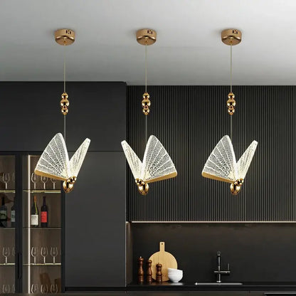 Three elegant gold-finished butterfly-shaped led pendant lights with intricate crystal mesh detailing for kitchens and dining rooms