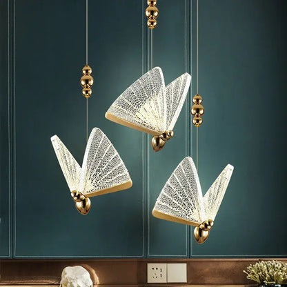 Three elegant gold-toned butterfly led pendant lights with intricate white lace glass wings for kitchen and dining room