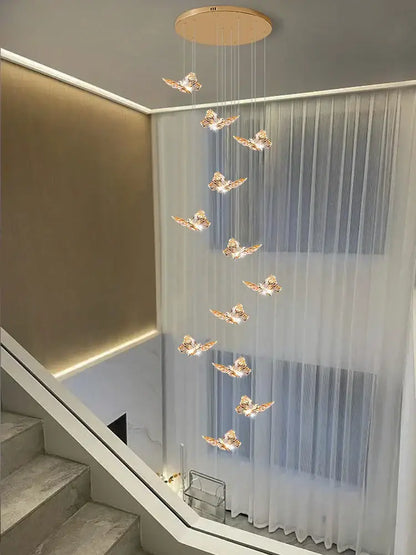 Golden butterfly pendant light with illuminated wings hanging from a circular ceiling fixture butterfly chandelier staircase