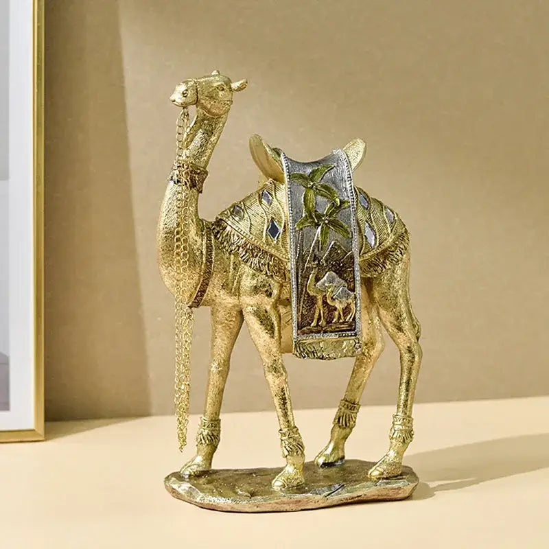 Golden camel resin sculpture by decorbites featuring intricate detailing and a decorative saddle with palm tree motifs