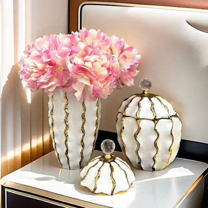 White ceramic vase with gold wavy stripes and crystal knob holding pink peonies from decorbites golden checkmate ceramic jar