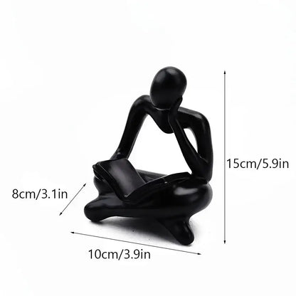 Black glossy resin figurine of a seated thinker with hands on chin and legs crossed for decorbites abstract thinker decor