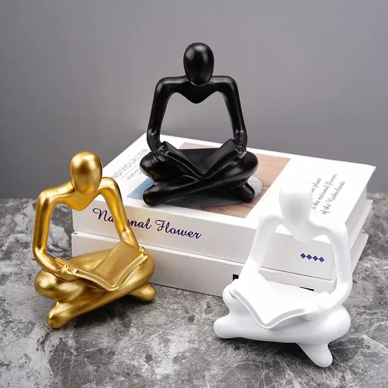 Three minimalist resin figurines in glossy gold, matte black, and white by decorbites abstract thinker office decor