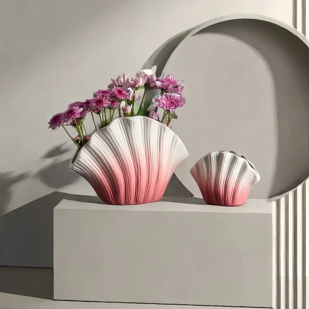 A sleek gradient shell ceramic vase with ribbed texture and scalloped edges in pink to white for living room decor