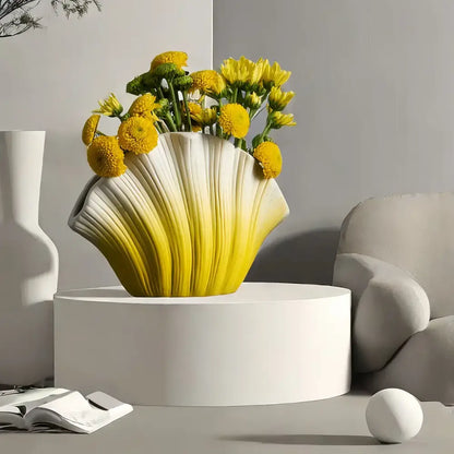 A vibrant yellow and white gradient shell ceramic vase filled with bright yellow flowers for living room decorbites decor