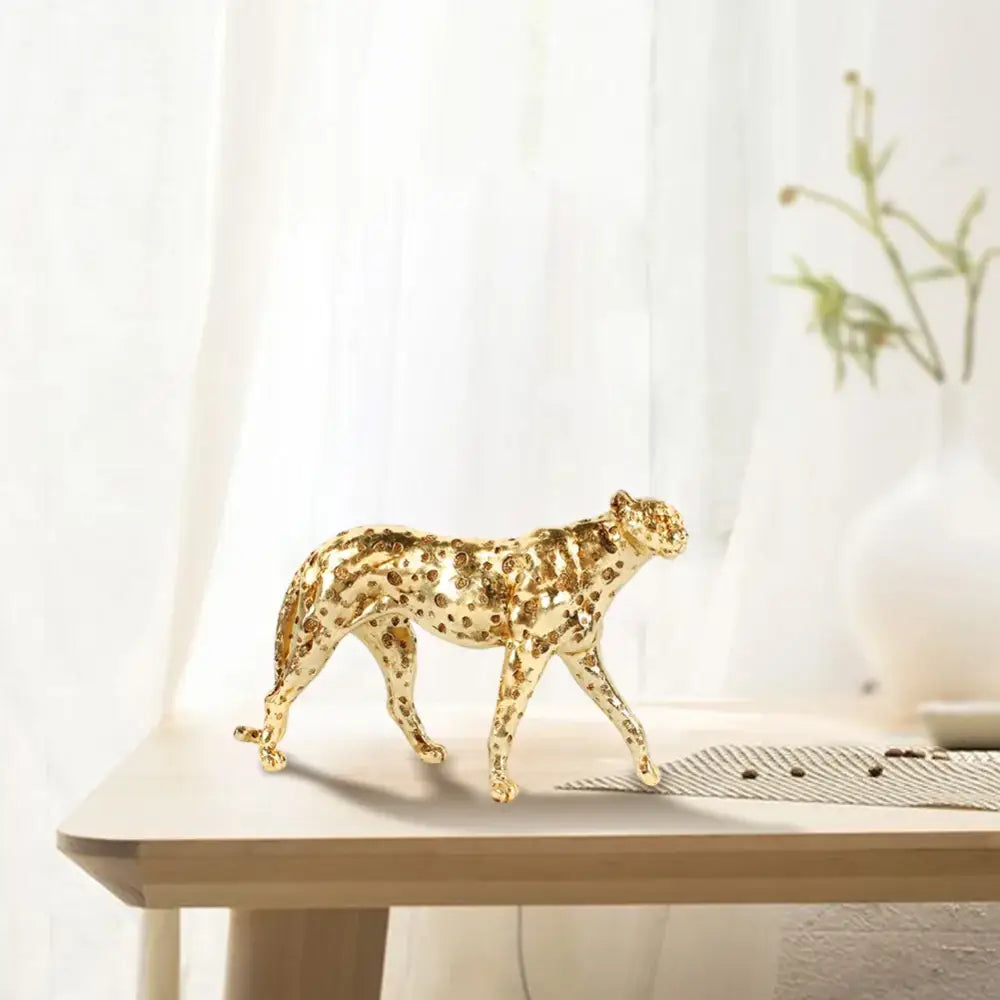 Golden leopard cheetah metallic sculpture with intricate spotted pattern in polished gold for living room decor