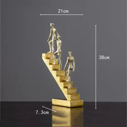 Golden man abstract resin sculpture in metallic gold depicting three figures ascending a staircase for living room decorbites decor