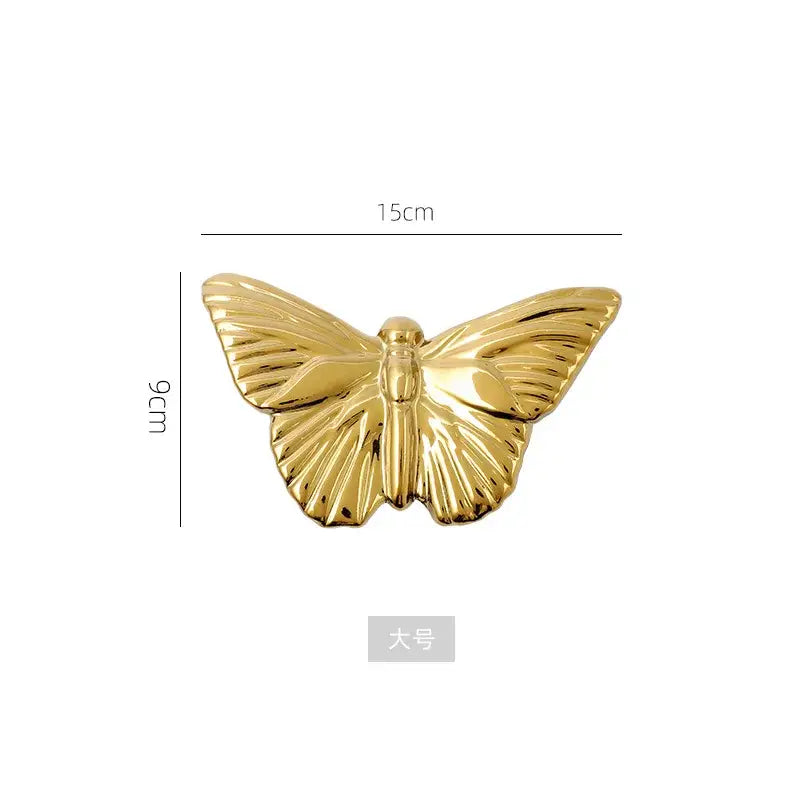 Golden metallic butterfly wall decoration set featuring a detailed polished butterfly-shaped decorative pin for living room