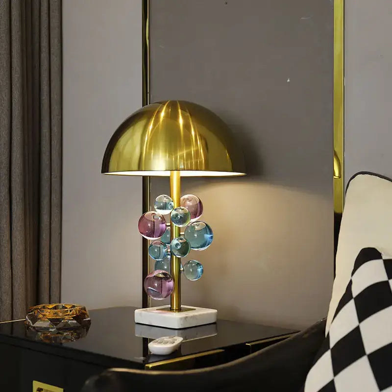 A modern table lamp with a polished gold dome shade and colorful glass orbs for decorbites golden mushroom crystal lighting