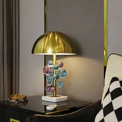 A modern table lamp with a polished gold dome shade and colorful glass orbs for decorbites golden mushroom crystal lighting