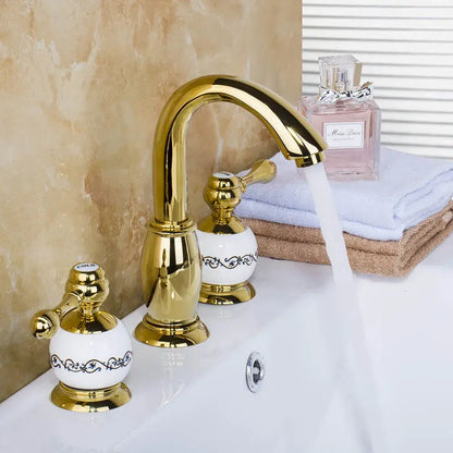 Golden plated bathroom faucet set with white ceramic handles featuring black floral patterns by decorbites