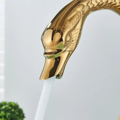 Golden swan dual handle deck mounted bathroom basin tap with polished metallic finish and detailed feathered neck for cold water