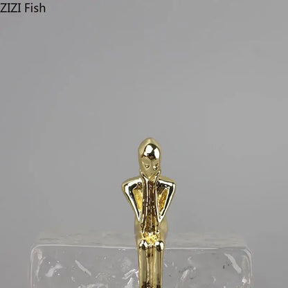Golden thinker ice crystal sculpture featuring a golden metallic figurine with elongated limbs for abstract decorbites decor