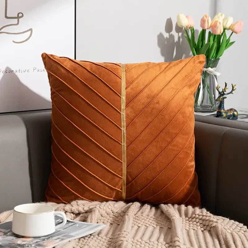 A plush orange velvet cushion cover with diagonal pleats and central gold trim from decorbites golden velvet patchwork set