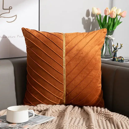 A plush orange velvet cushion cover with diagonal pleats and central gold trim from decorbites golden velvet patchwork set