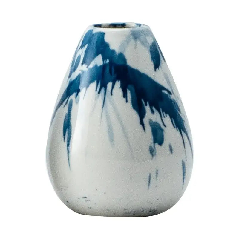 A teardrop-shaped ceramic vase with glossy white glaze and bold blue brushstroke patterns for decorbites graffiti ceramic use