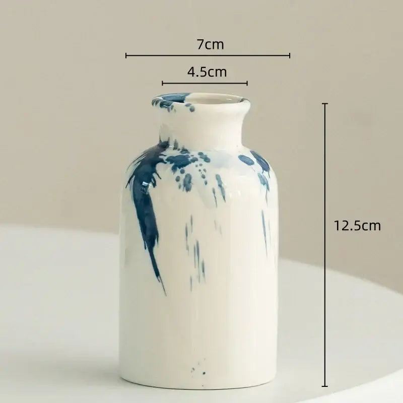 A white ceramic vase with blue splatter paint design decorbites graffiti ceramic vase for living room decor