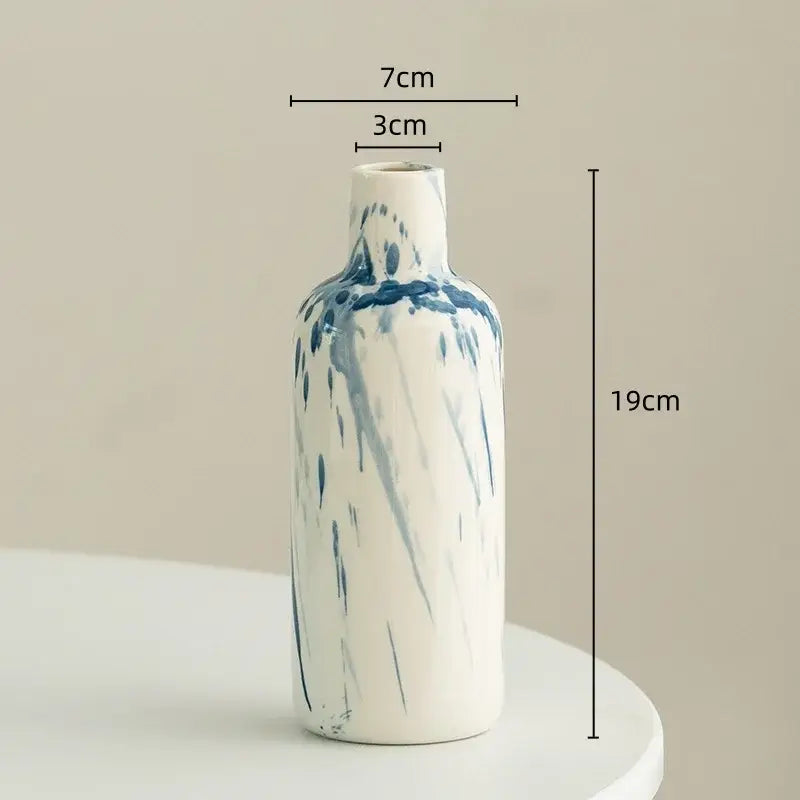 A slender white ceramic vase with blue abstract splatter patterns from decorbites graffiti ceramic vase collection