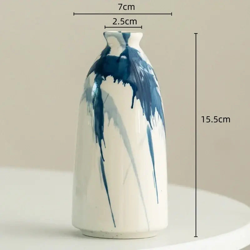 A slender white ceramic vase with bold blue dripping brushstrokes decorbites graffiti ceramic vase for living room decor