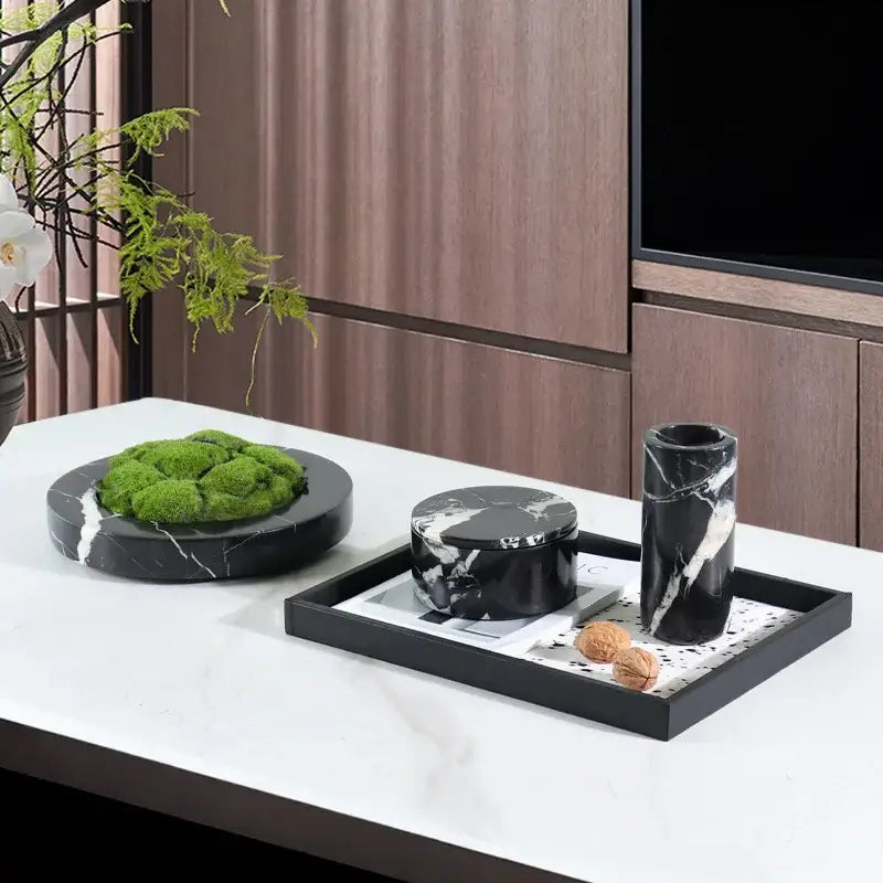 Black marble tray with white veining holding a round black marble storage jar and tall vase from decorbites grand antique collection