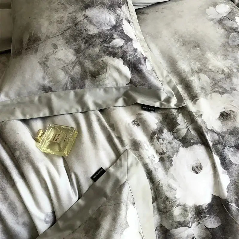 A gold-toned chanel perfume bottle on gray and white ruffled decorbites flowers pattern brushed bedding set