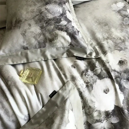 A gold-toned chanel perfume bottle on gray and white ruffled decorbites flowers pattern brushed bedding set