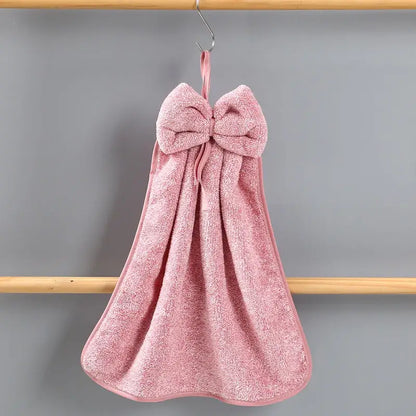 Pink bowknot coral velvet hand towel by decorbites hanging from a hook for kitchen cleaning use