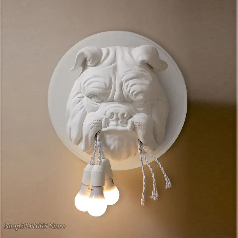 White sculpted decorbites bulldog resin wall lamp with three exposed bulbs hanging from its mouth for bedroom use