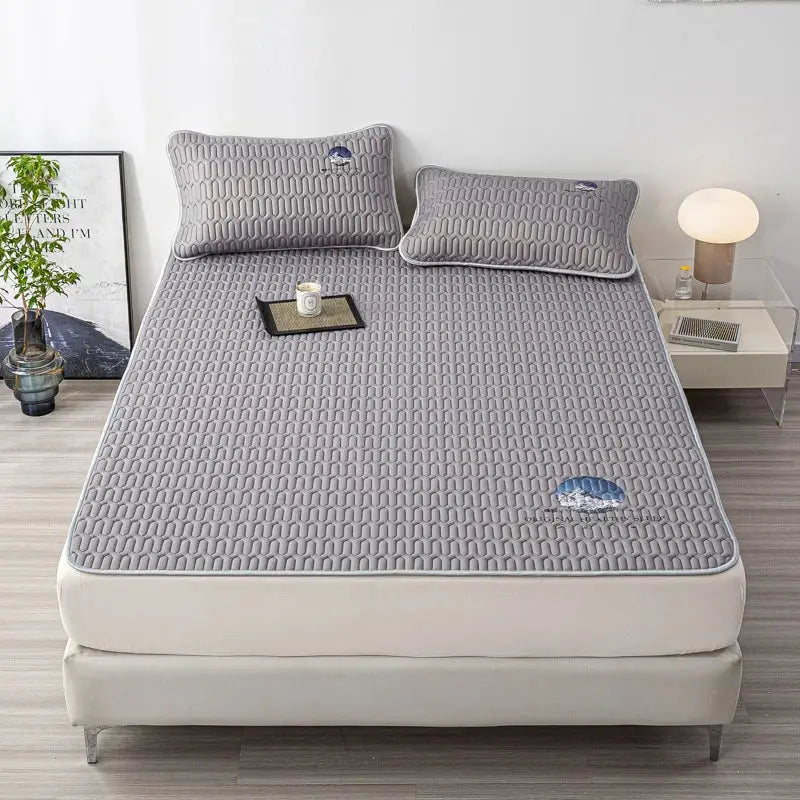 Gray quilted latex bed mat set with subtle textured pattern and small embroidered cloud motifs for bedroom use