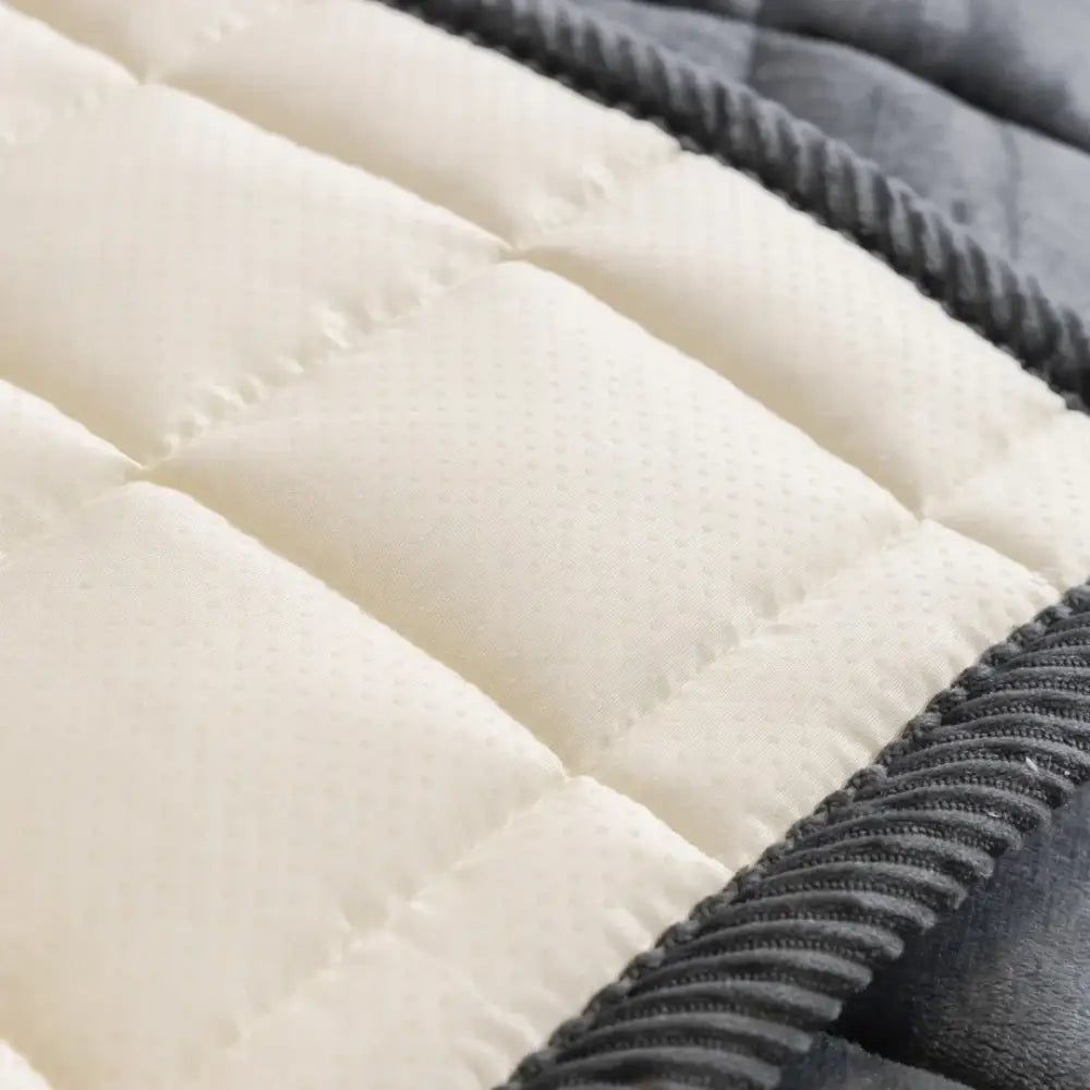 Cream-colored quilted sofa towel with textured dotted surface and dark gray corduroy-like border for living room use