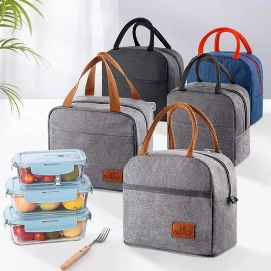 Gray textured insulated lunch bag with brown leather handles and matching rectangular brand patch for kitchen use
