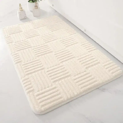 Cream-colored plush floor mat with textured checkered pattern for bathroom use in a soft non slip design
