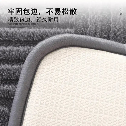 Gray plush striped floor mat with textured white mesh backing and reinforced durable edge for bathroom use