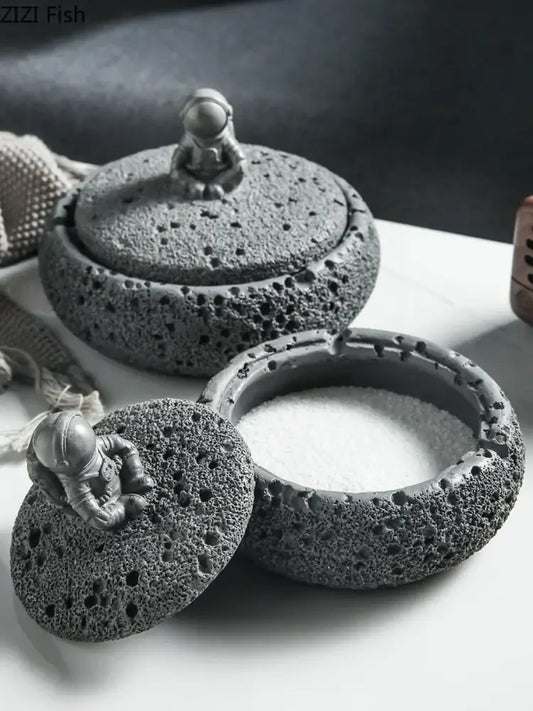 Gray volcanic stone ashtray featuring a miniature cement astronaut figurine for living room use as an astronaut ashtray