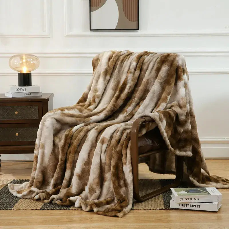 A mottled brown and cream fuzzy faux fur blanket draped over an armchair perfect for decorbites fuzzy faux decor
