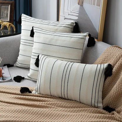 Cream-colored throw pillows with black stripe crochet and tassels in a green black stripe cushion cover design