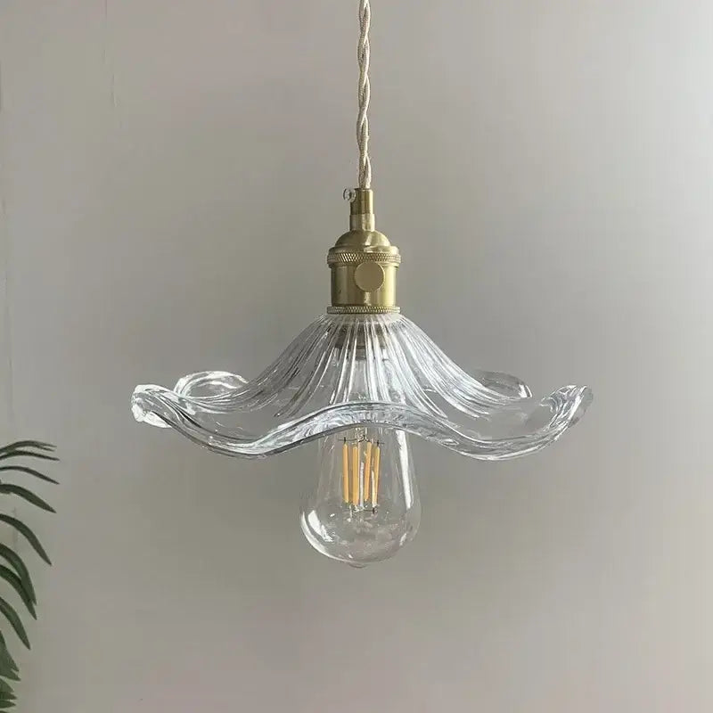 Clear glass pendant light with fluted petal shade and polished copper brass hardware for dining room use