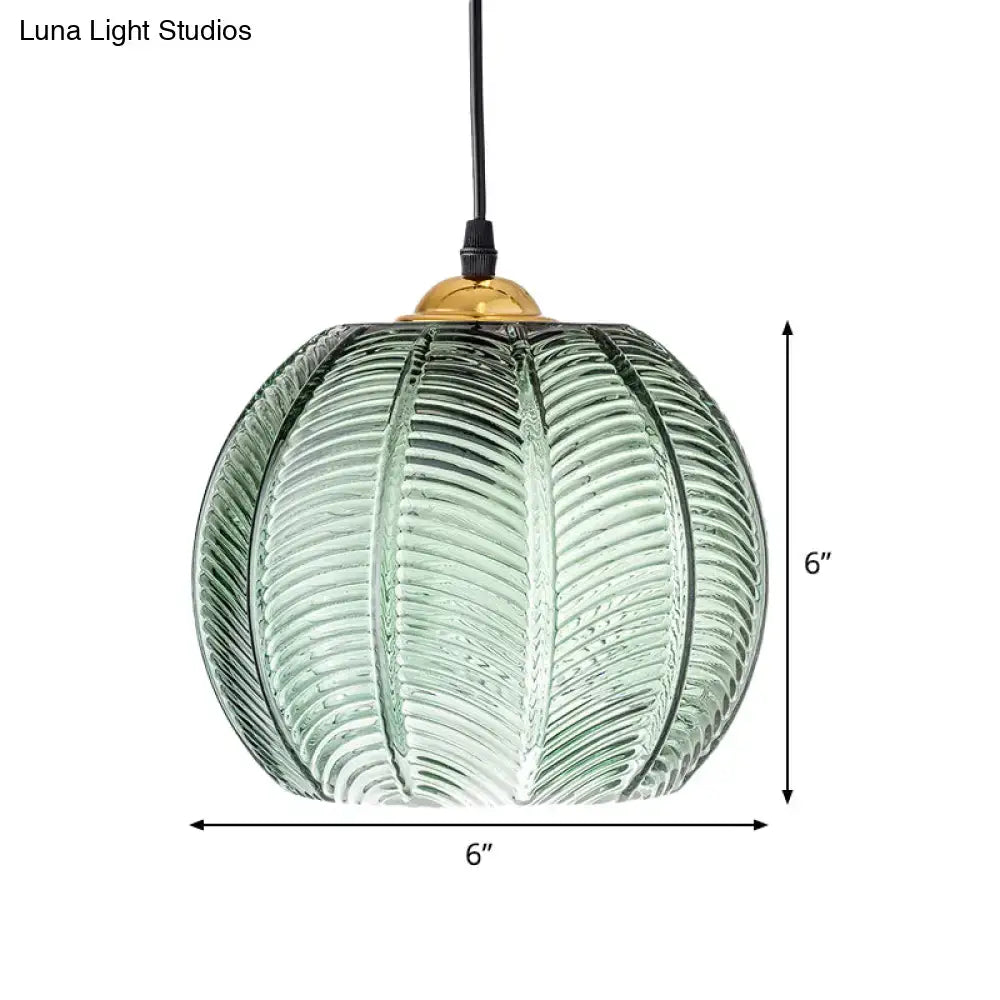 Green ribbed glass pendant lamp with a 6 inch diameter textured pumpkin design and brass finished top for dining room