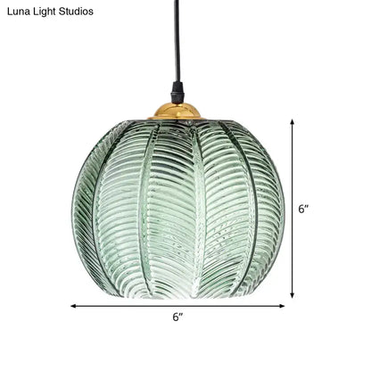 Green ribbed glass pendant lamp with a 6 inch diameter textured pumpkin design and brass finished top for dining room