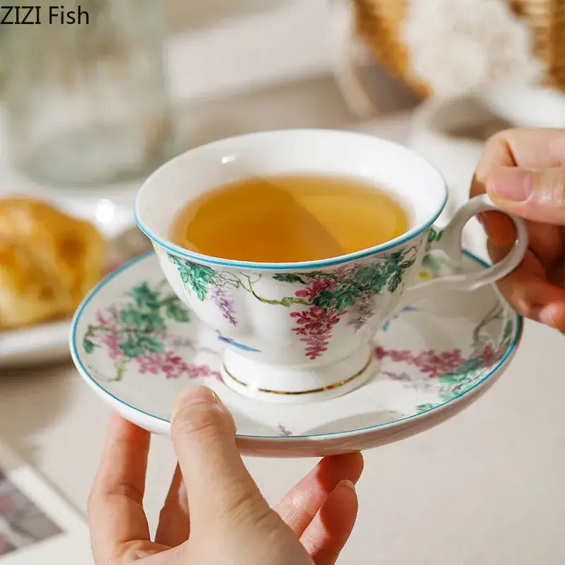 Delicate white porcelain teacup and saucer with pink wisteria and green vine flower decoration by decorbites green vine