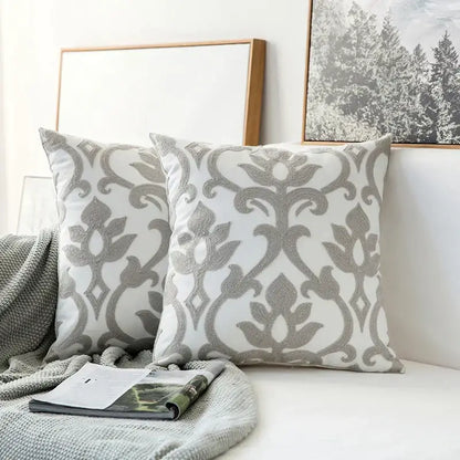 White throw pillows with intricate silver-gray embroidered floral patterns on decorbites grey geometric cushion cover