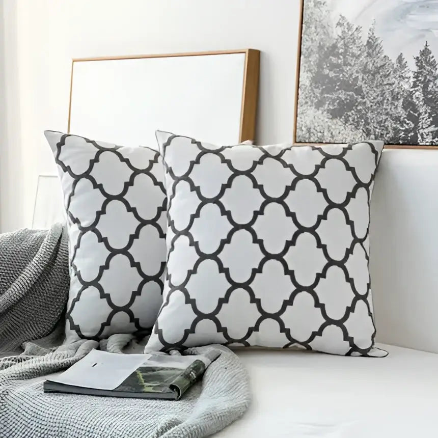 White throw pillows with black quatrefoil patterns featured in decorbites grey geometric embroidered cushion cover design